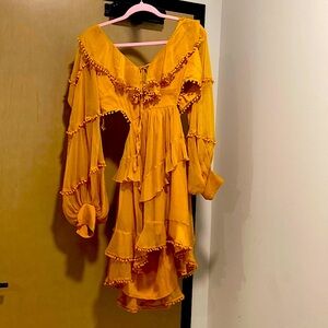Beautiful mustard dress with tassel detailing and open cut style on sides